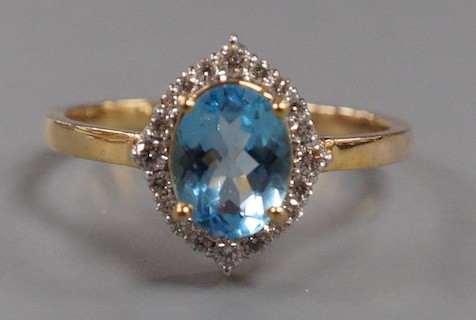 A modern 9k yellow metal, blue topaz and diamond chip set navette shaped cluster ring, size Q, gross weight 3 grams.